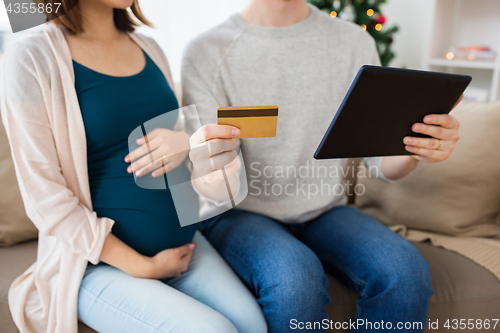 Image of close up of man with pregnant wife shopping online
