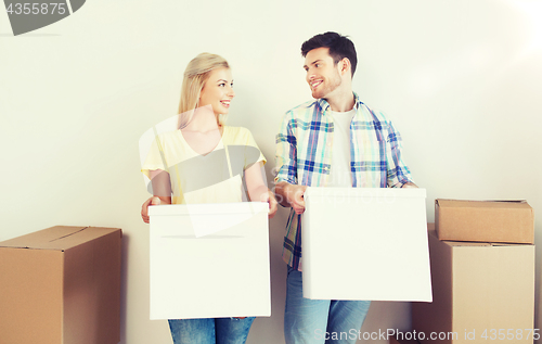 Image of smiling couple with big boxes moving to new home