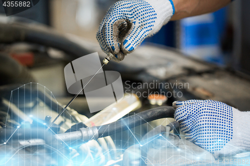 Image of mechanic with dipstick checking motor oil level