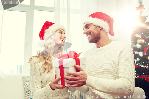 Image of happy couple at home with christmas gift box