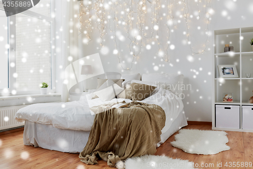 Image of bedroom with bed and christmas garland at home