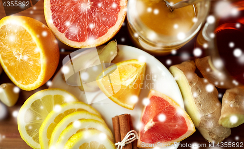 Image of ginger tea with honey, citrus and garlic on wood