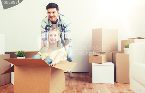 Image of happy couple having fun with boxes at new home