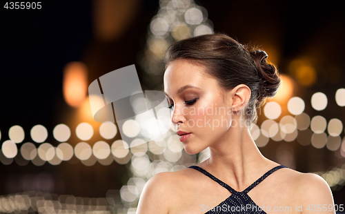 Image of beautiful asian woman over christmas tree lights