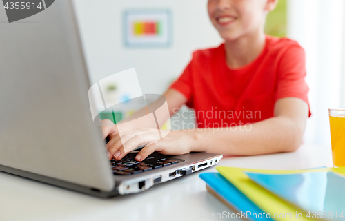 Image of student boy typing on laptop computer at home