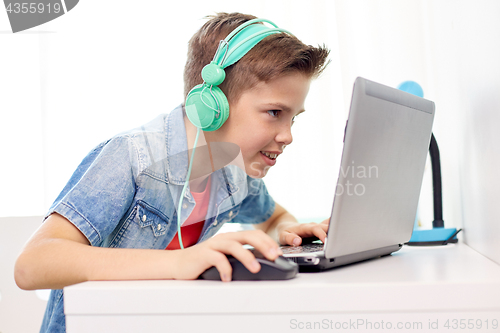 Image of boy in headphones playing video game on laptop