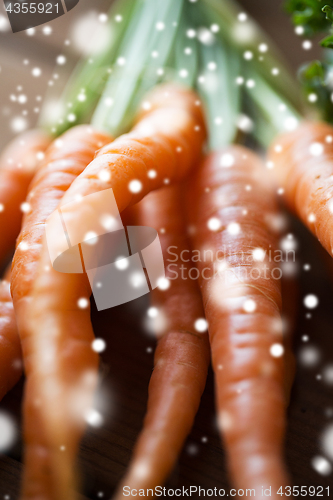 Image of close up of carrot bunch on wooden table