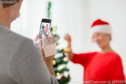 Image of close up of senior man picturing wife at christmas