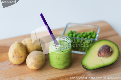 Image of jar with puree or baby food on wooden board