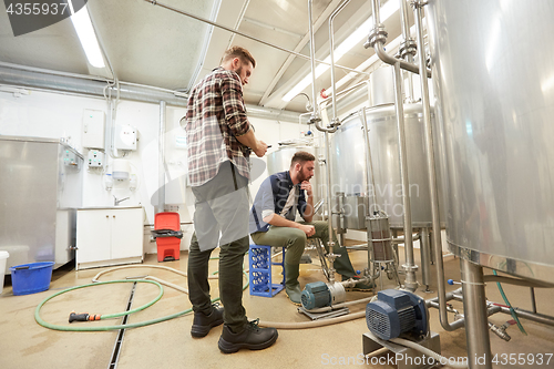 Image of men with tablet pc at craft beer brewery filter