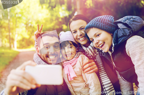 Image of happy family taking selfie by smartphone outdoors