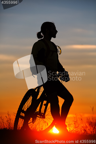 Image of Silhouette of a bike on sky background
