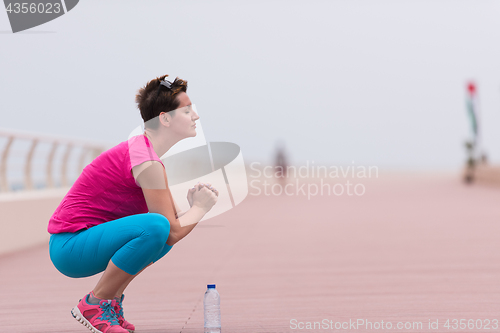 Image of woman stretching and warming up on the promenade