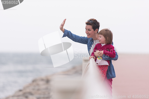 Image of mother and cute little girl on the promenade by the sea