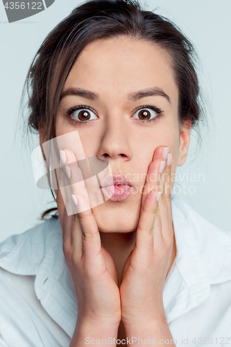 Image of Portrait of young woman with shocked facial expression