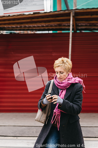 Image of Woman with phone on city street