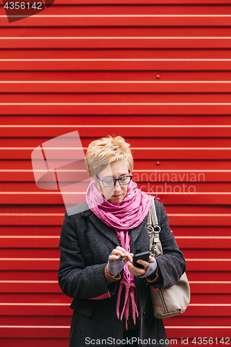 Image of Adult woman with smartphone on street