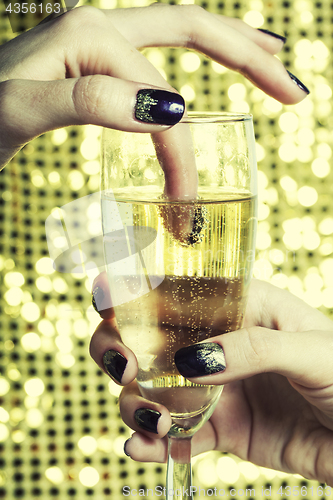 Image of beauty close up photo fingers with manicure holding glass of champagne