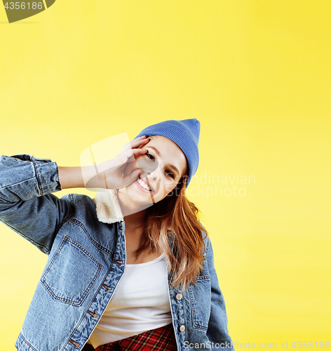 Image of lifestyle people concept: pretty young school teenage girl having fun happy smiling on yellow background