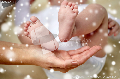 Image of close up of newborn baby feet in mother hands