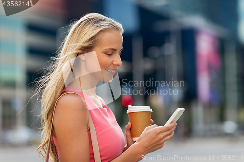 Image of woman with coffee and smartphone in city