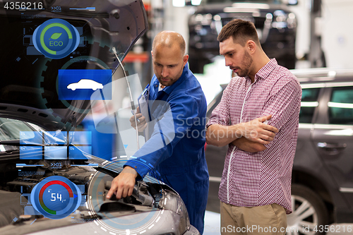 Image of auto mechanic with clipboard and man at car shop