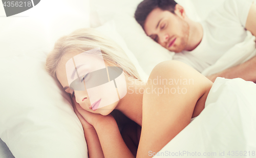 Image of happy couple sleeping in bed at home