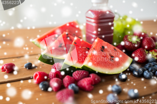 Image of watermelon, bottle of fruit juice and berries