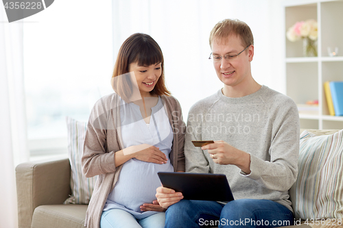 Image of husband and pregnant wife shopping online at home