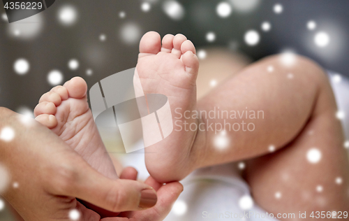 Image of close up of newborn baby feet in mother hands