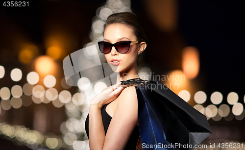 Image of woman in shades with shopping bags at christmas