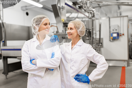 Image of happy women technologists at ice cream factory