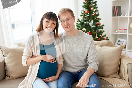 Image of pregnant wife with husband at home at christmas