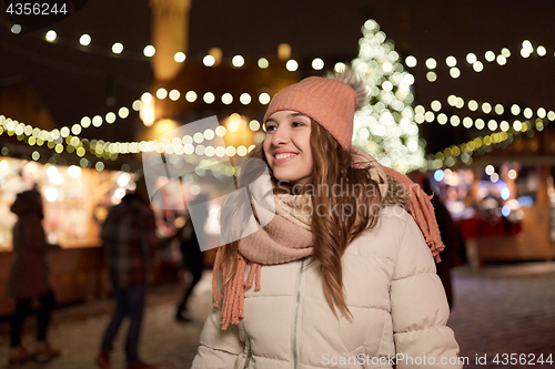 Image of happy young woman at christmas market in winter