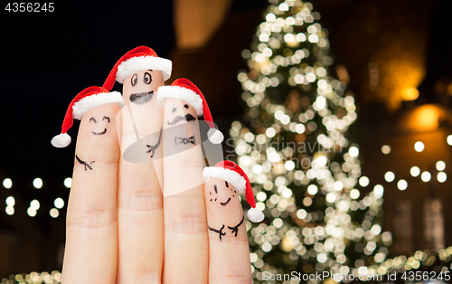 Image of close up of fingers in santa hats at christmas