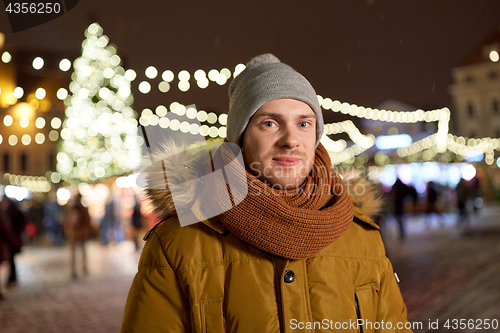 Image of happy man in winter clothes at christmas market