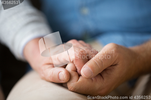 Image of close up of senior couple holding hands