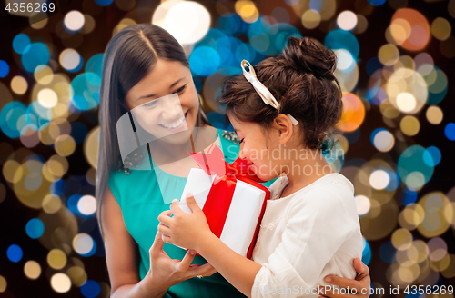 Image of happy mother and daughter girl with gift box