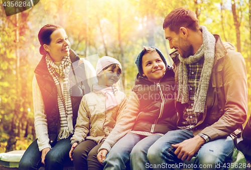 Image of happy family sitting on bench and talking at camp