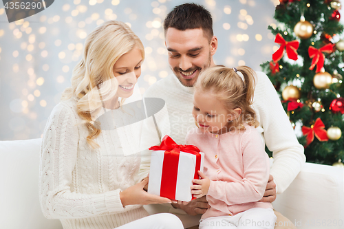 Image of happy family at home with christmas gift box