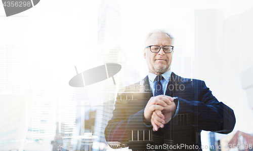 Image of senior businessman checking time on his wristwatch