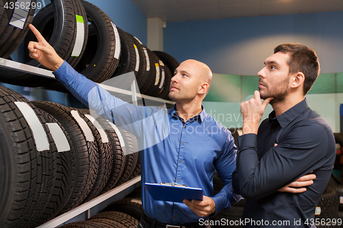 Image of customer and salesman at car service or auto store