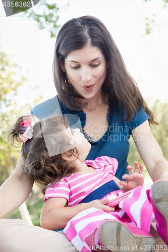 Image of Mixed Race Mother and Cute Baby Daughter Playing with Cell Phone