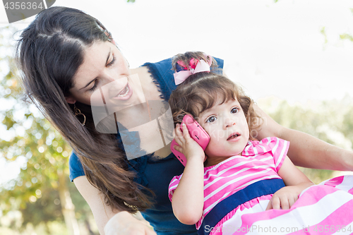 Image of Mixed Race Mother and Cute Baby Daughter Playing with Cell Phone