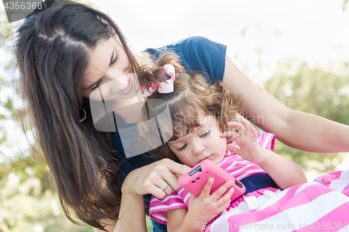 Image of Mixed Race Mother and Cute Baby Daughter Playing with Cell Phone