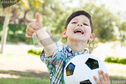 Image of Cute Young Boy Playing with Soccer Ball and Thumbs Up Outdoors i