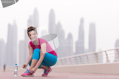 Image of woman tying shoelaces on sneakers