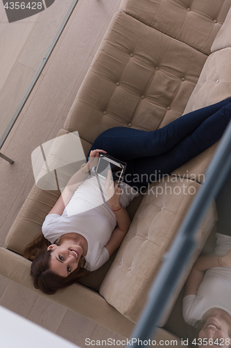 Image of woman on sofa using tablet computer