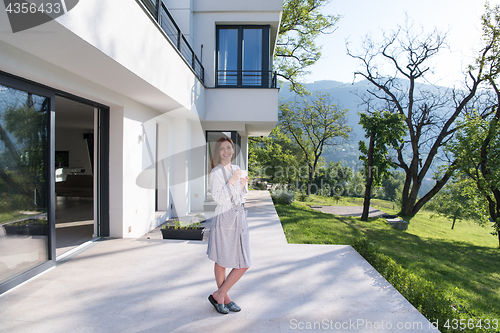 Image of woman in a bathrobe enjoying morning coffee