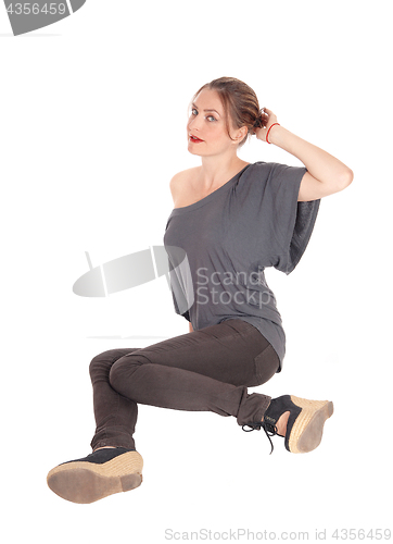 Image of Woman sitting on floor and looking up